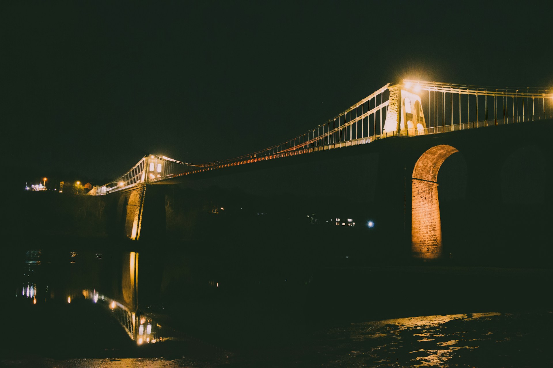 A suspension bridge lit up at night