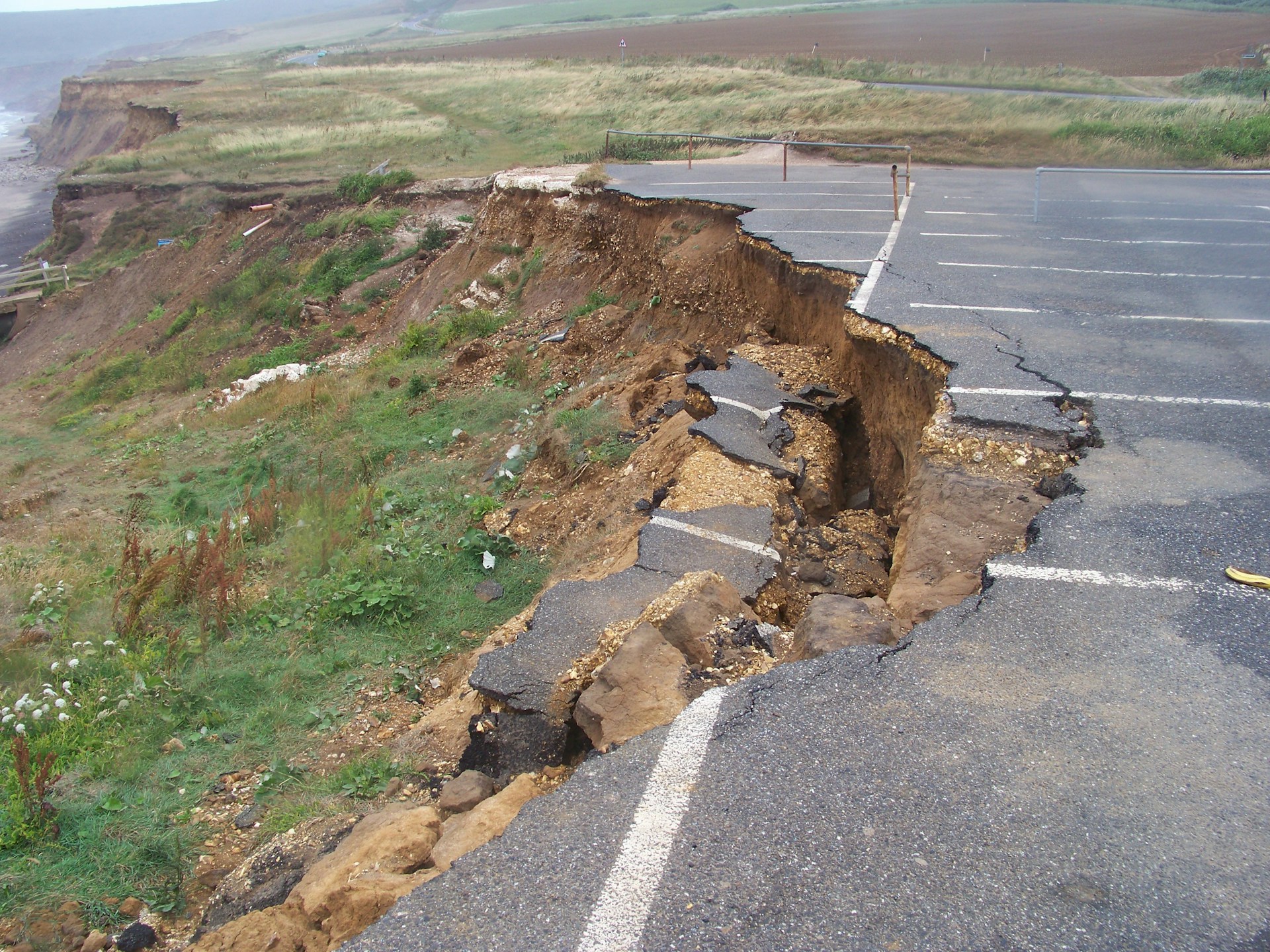 A cracked and broken carpark on a cliff's edge following an earthquake