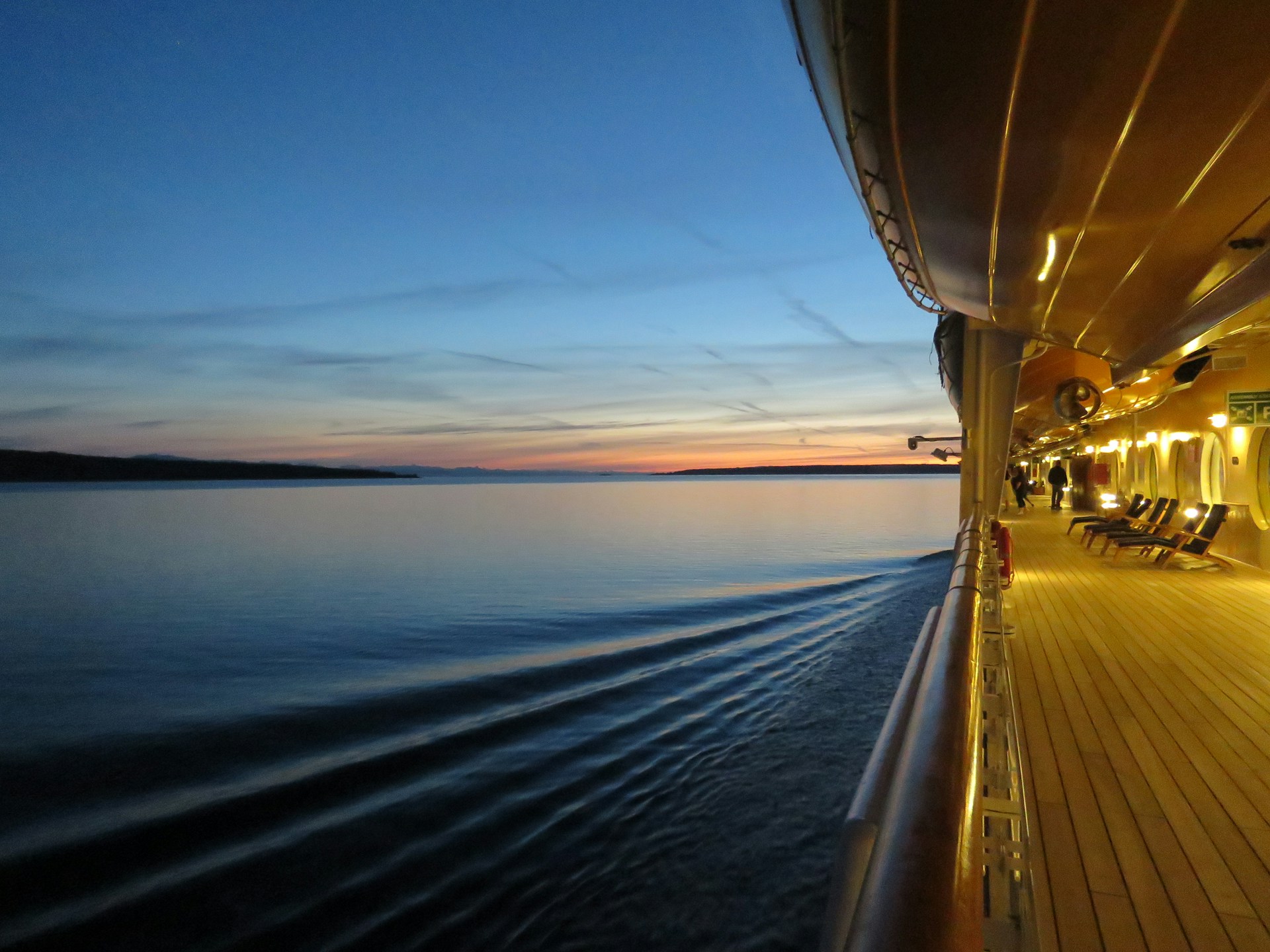 a walkway on a cruise ship at sunset