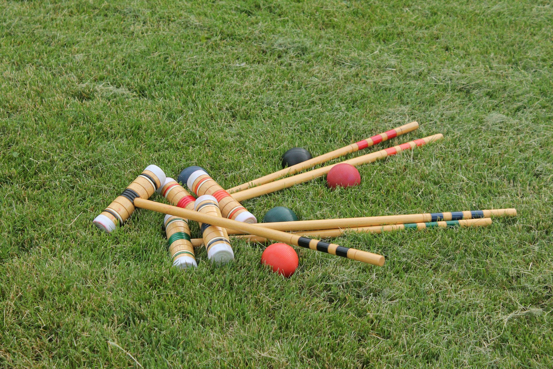 Croquet sticks and balls lying on grass