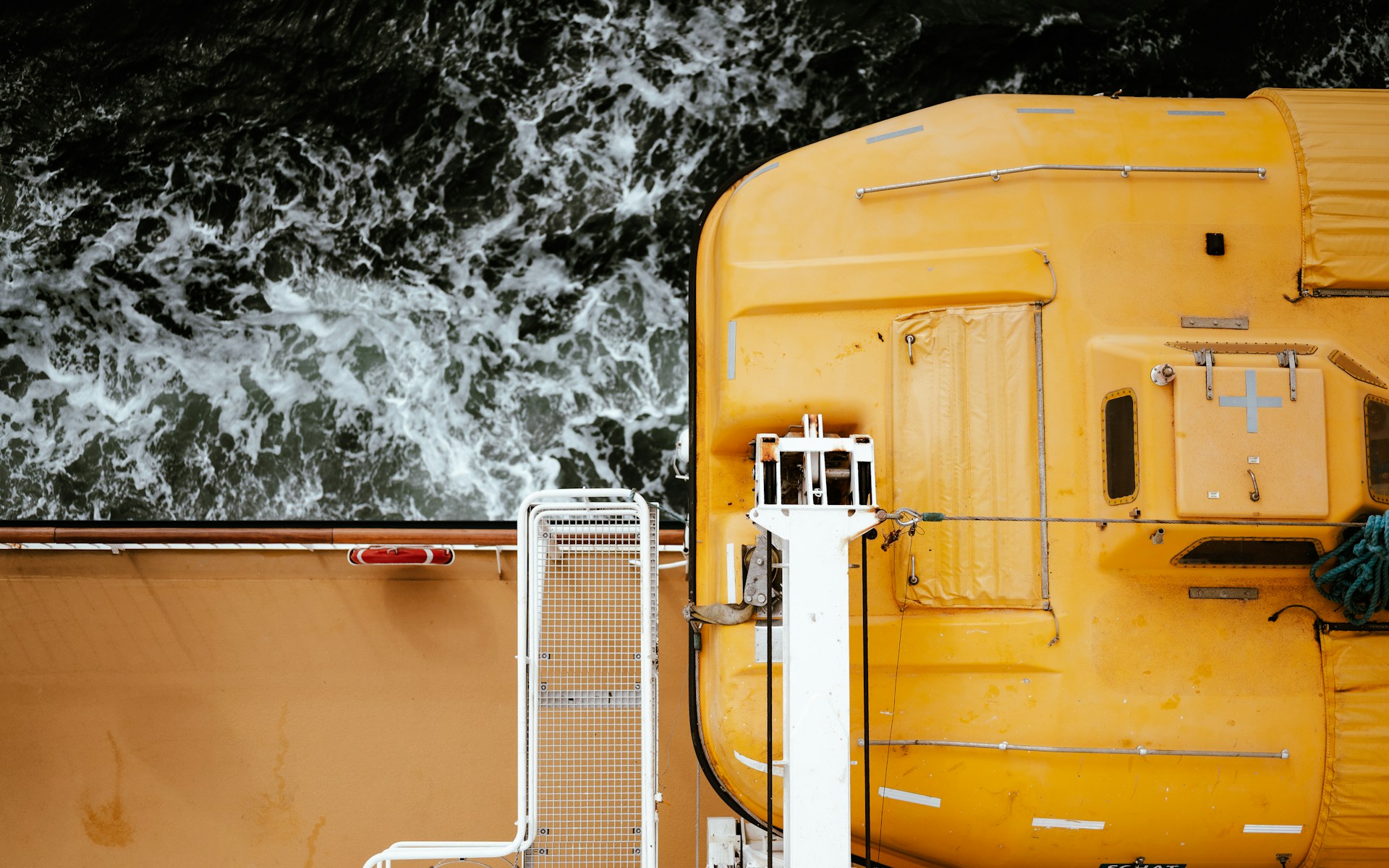 A yellow lifeboat on the side of a vesse;