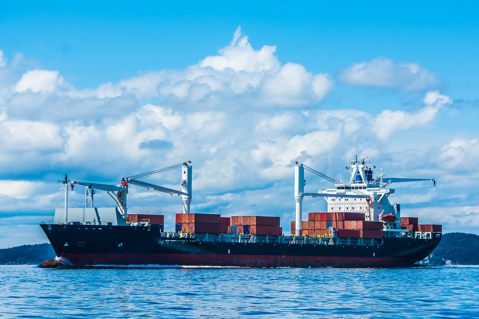 Container ship under blue cloudy sky