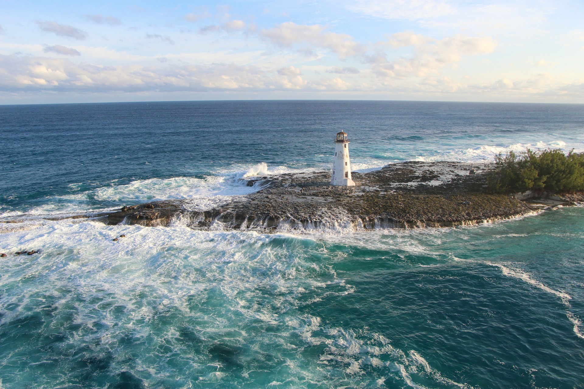 A lighthouse in the Bahamas surrounded by rough seas
