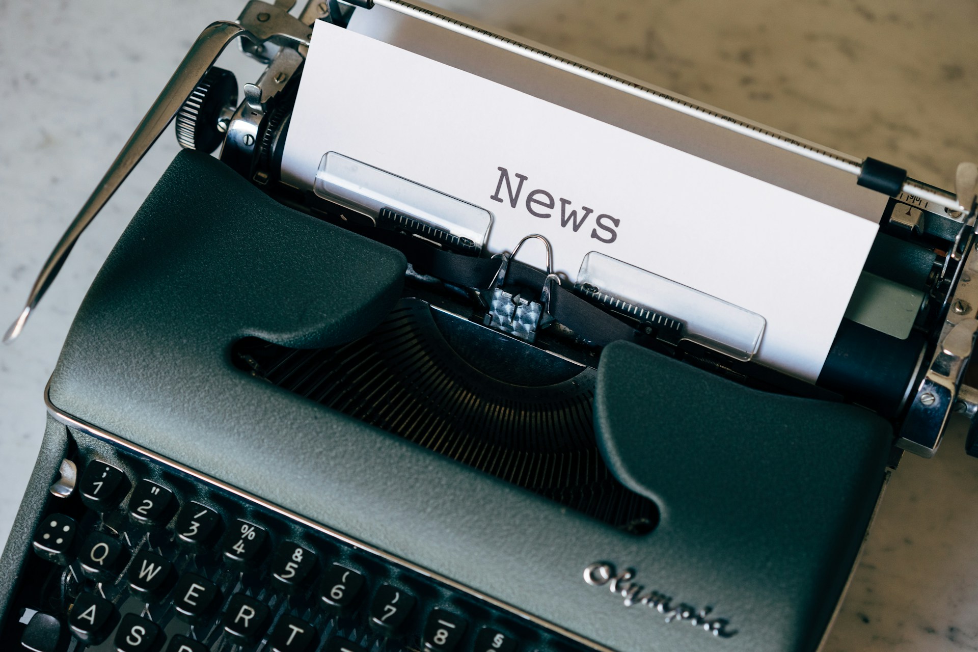 A typewriter with a piece of paper and the word /news' on it