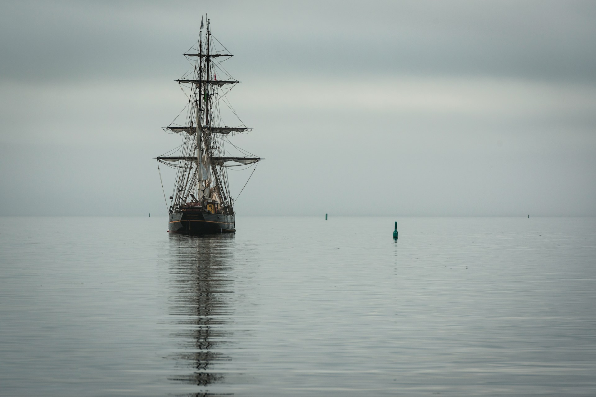 An unnamed tall ship sailing under a grey sky