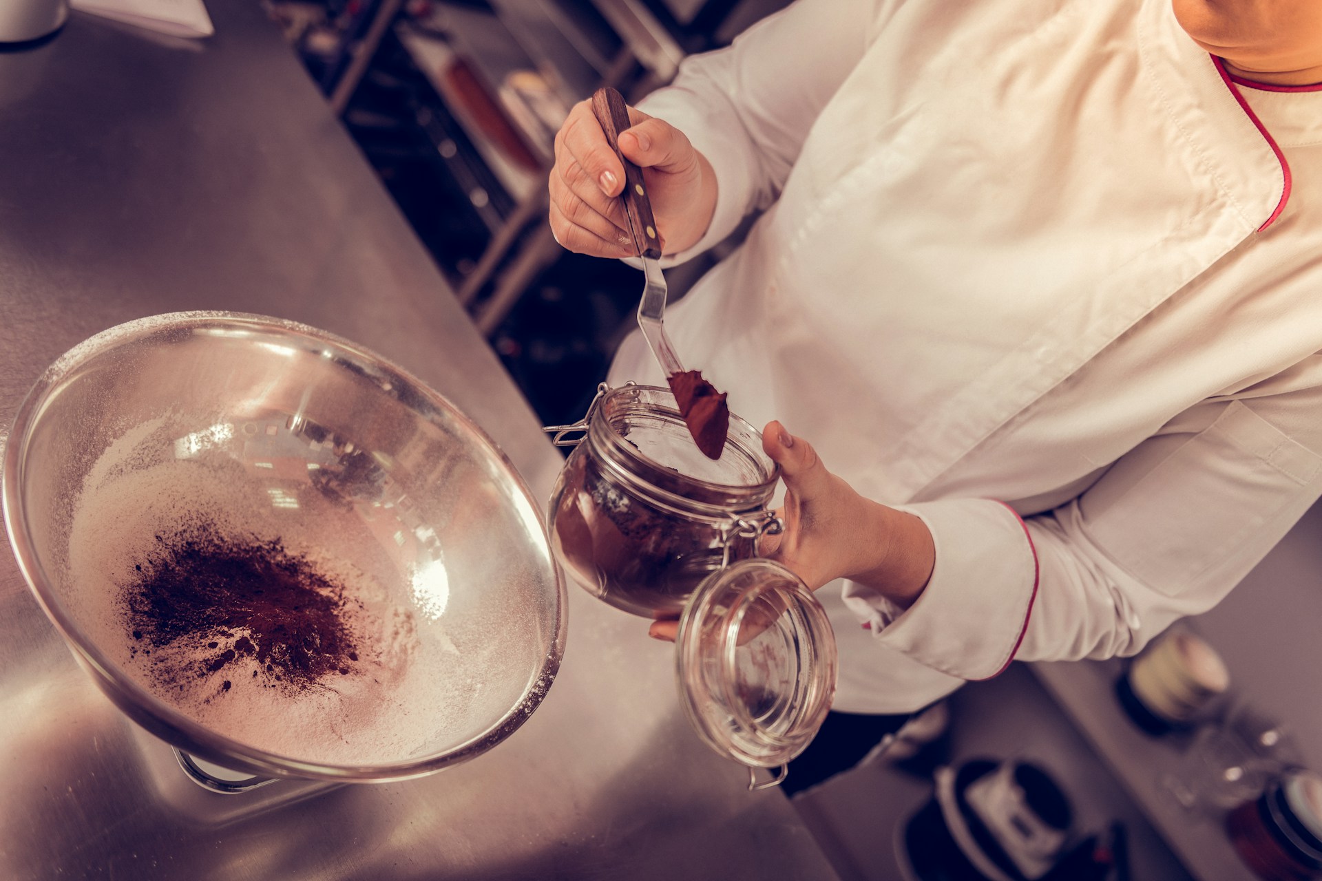 A chef adding chocolate powder to a desert recipe