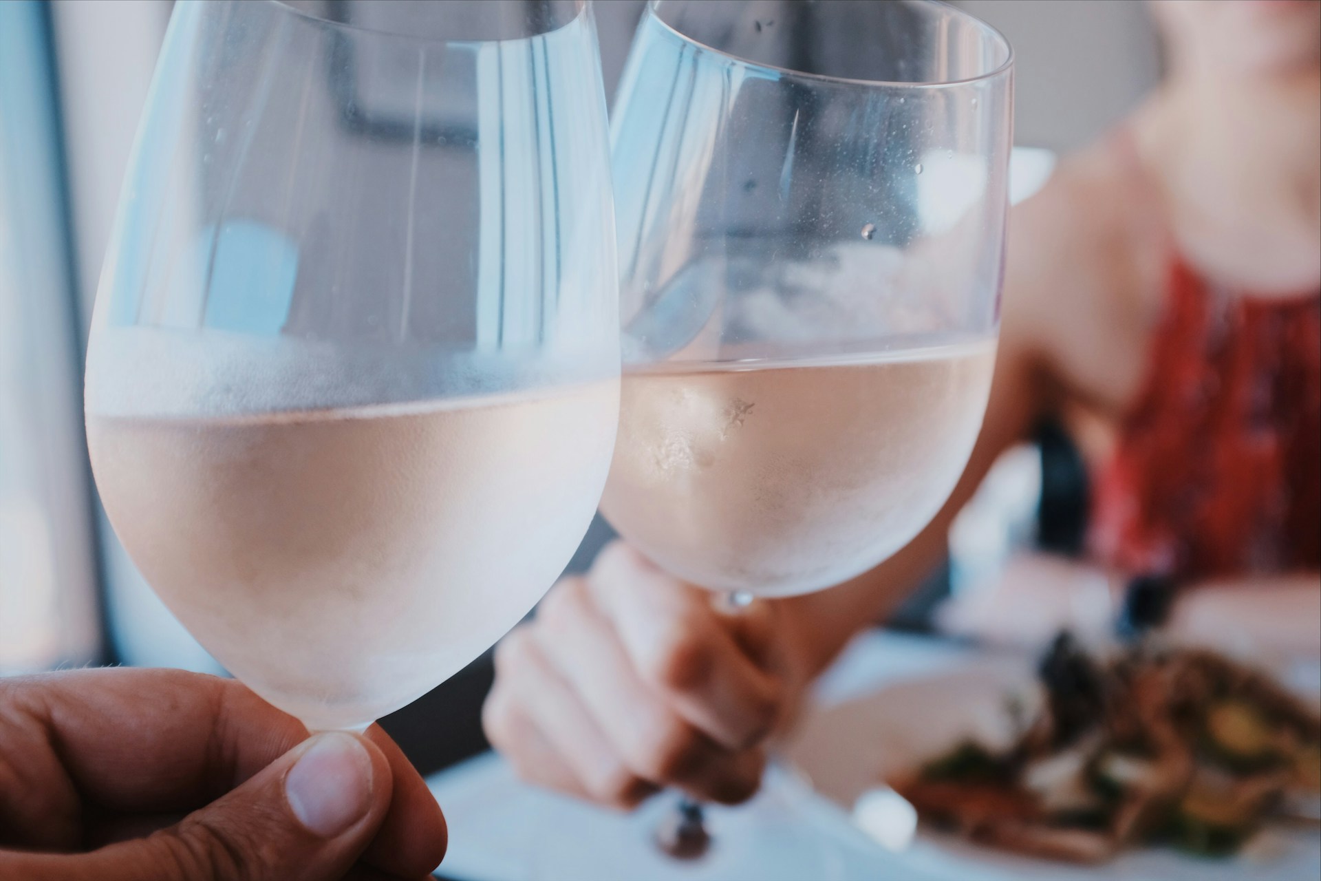 Two glasses of rose wine clinking