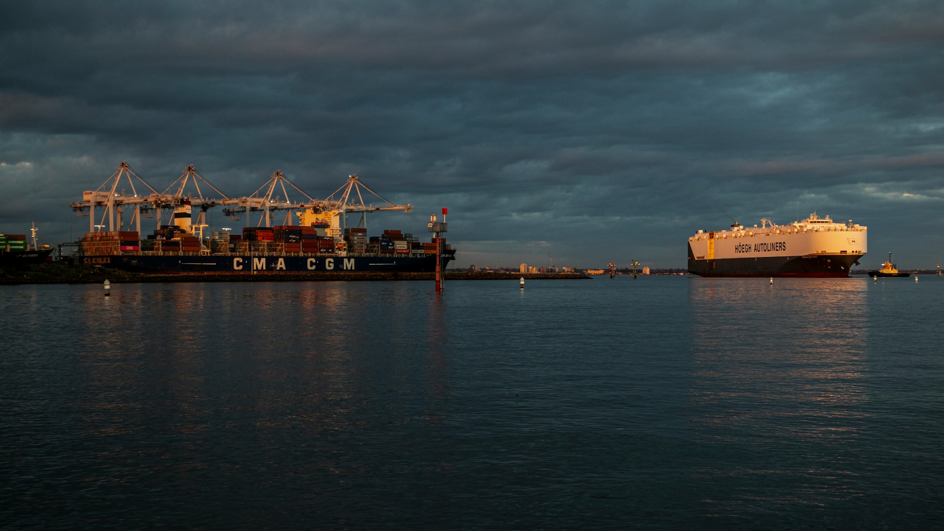 A CMA CGM vessel in port under a cloudy sky