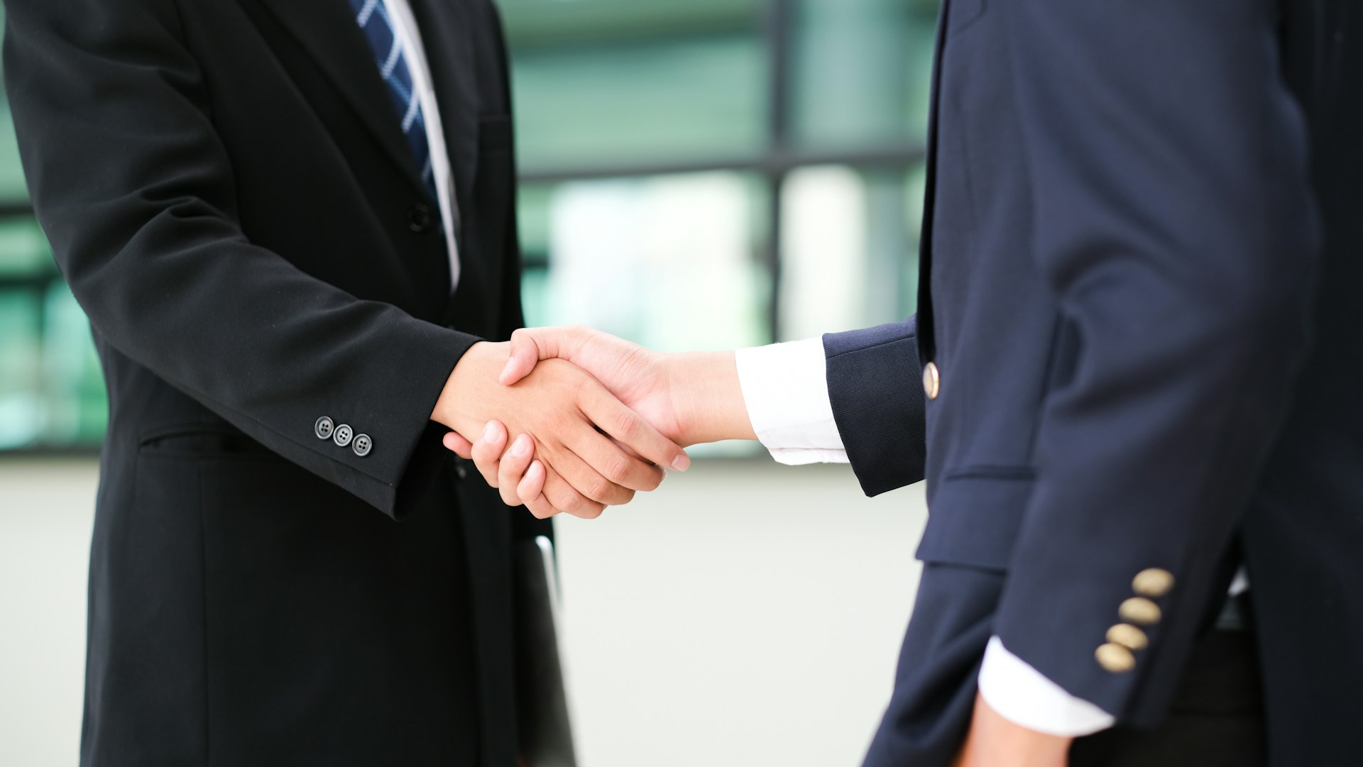 Two men in business attire shaking hands