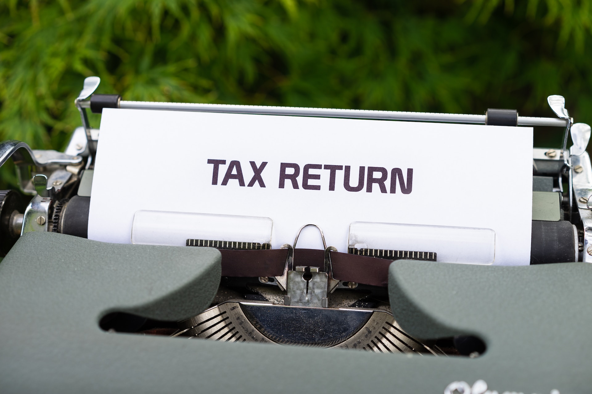 Typewriter with paper in it saying 'tax return'