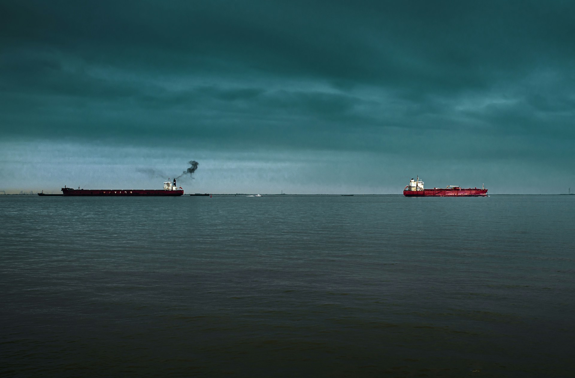 Two oil tankers under a dark sky