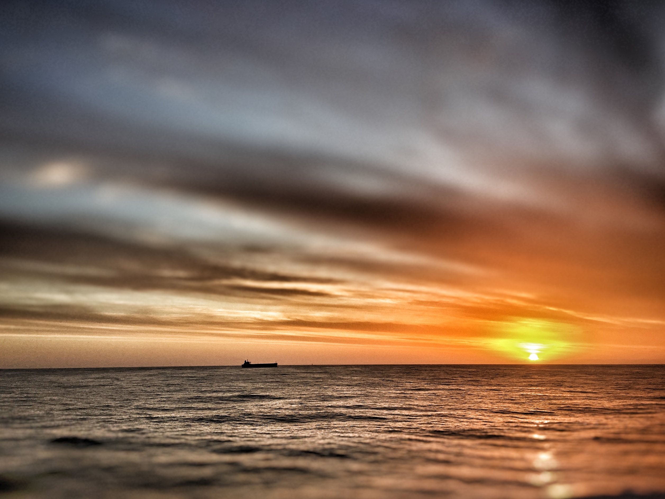 silhouette of a bulk carrier at sunset