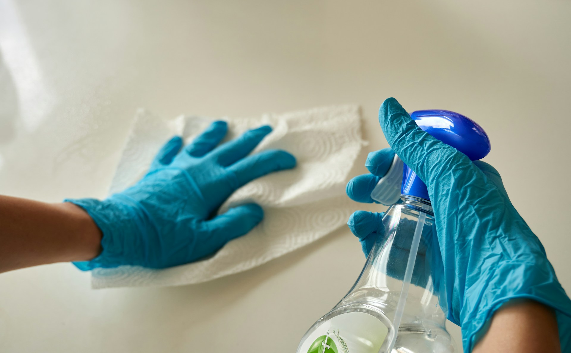 Hands holding a cloth and cleaning spray