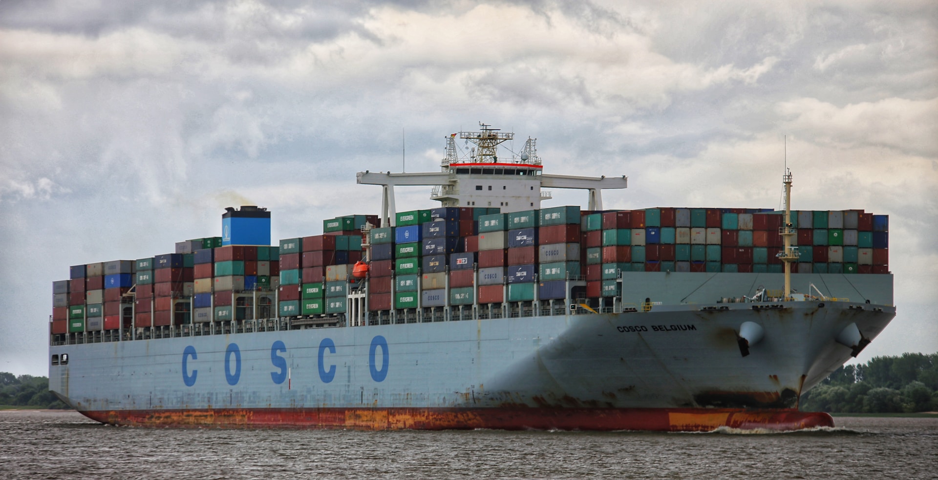 A COSCO container ship sailing near the shore