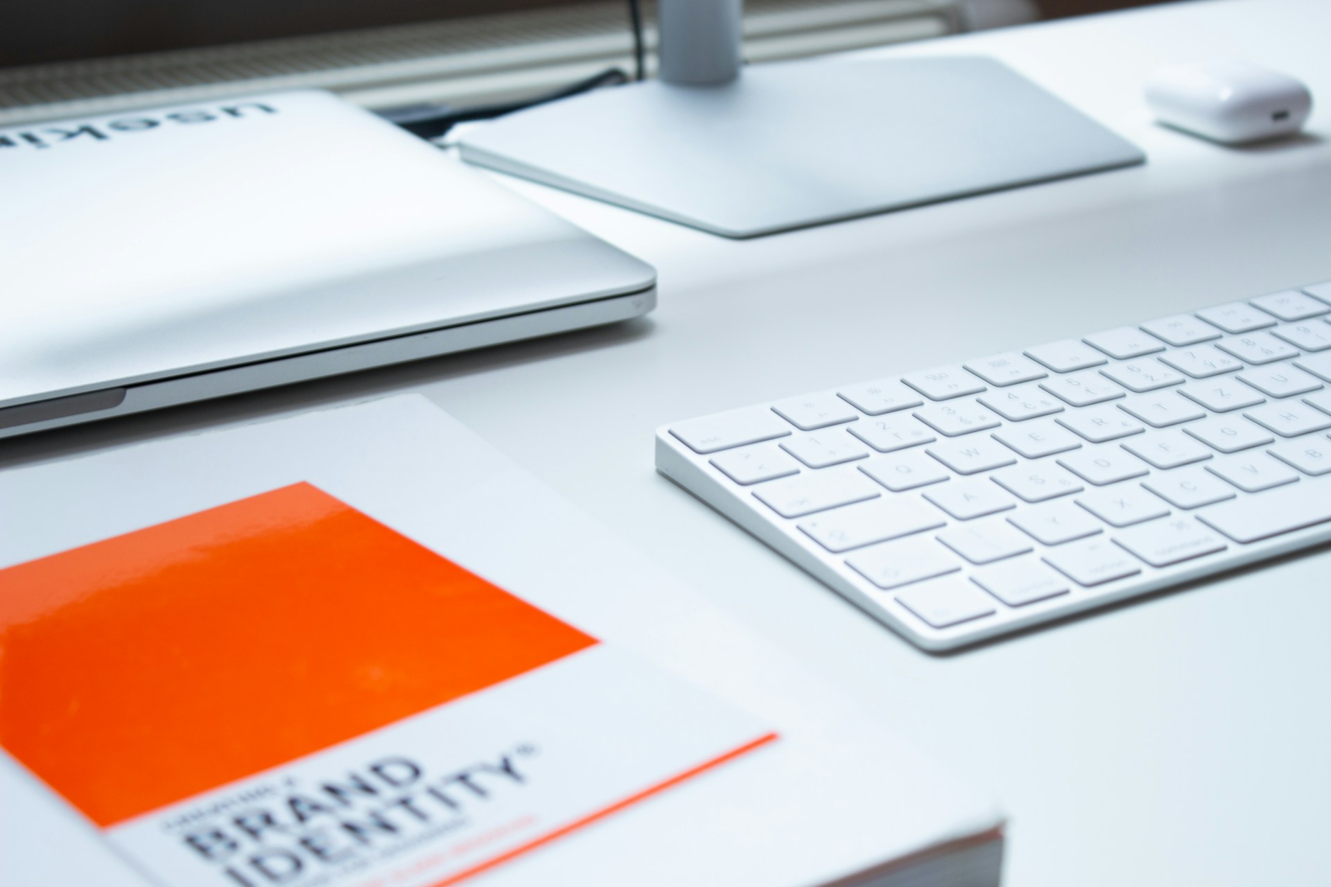 A computer keyboard and book entitled 'Brand Identity' 