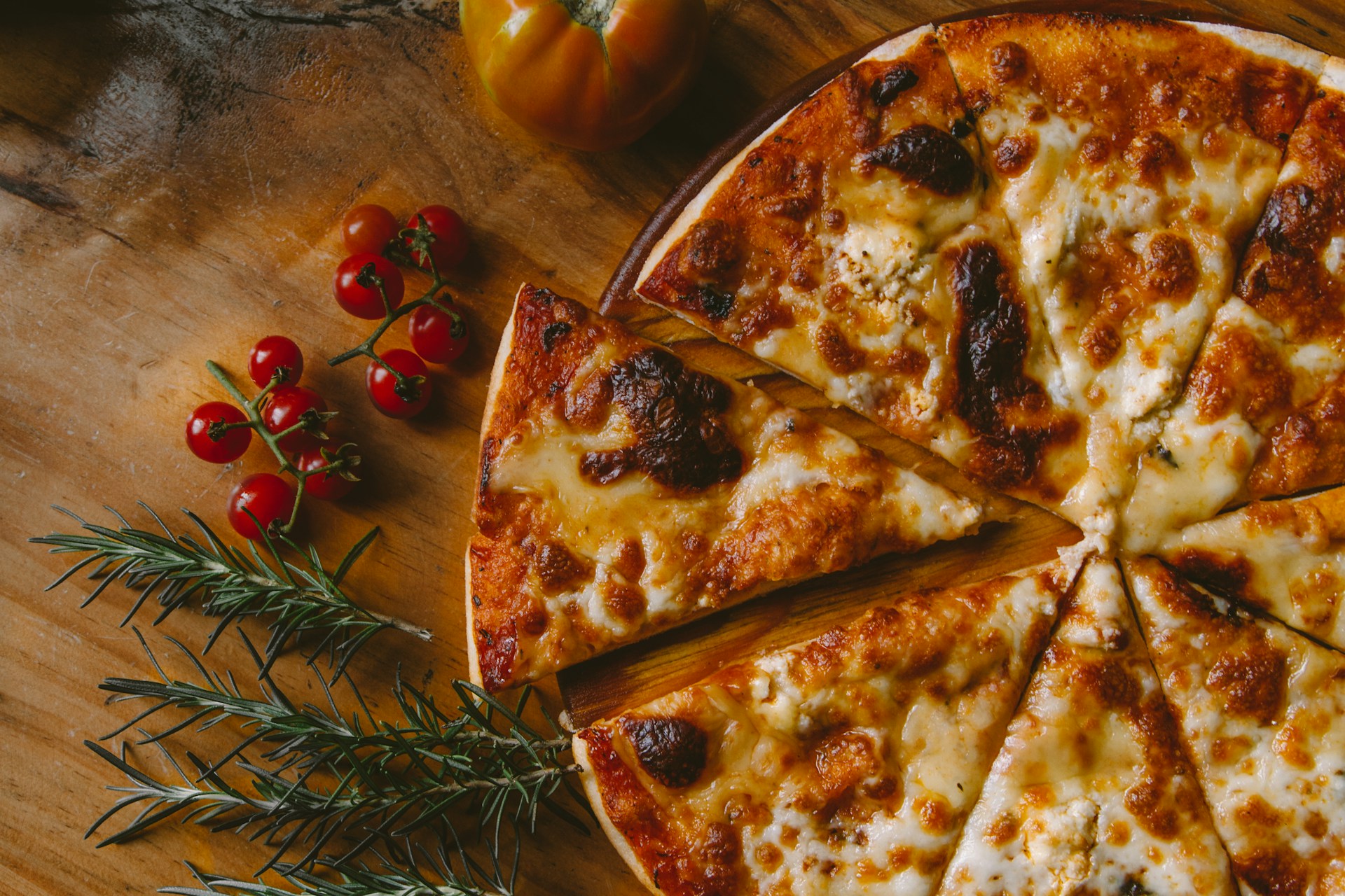 A freshly made pizza on a wooden serving board