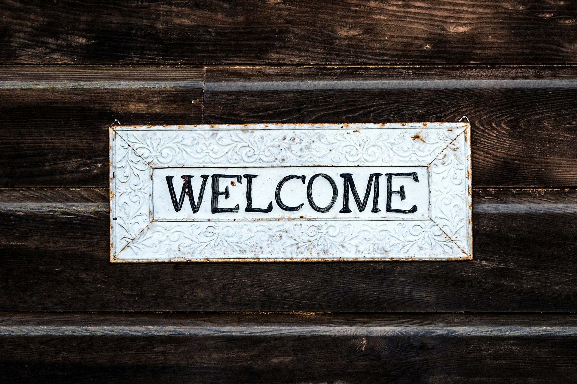 A tin welcome sign on wood