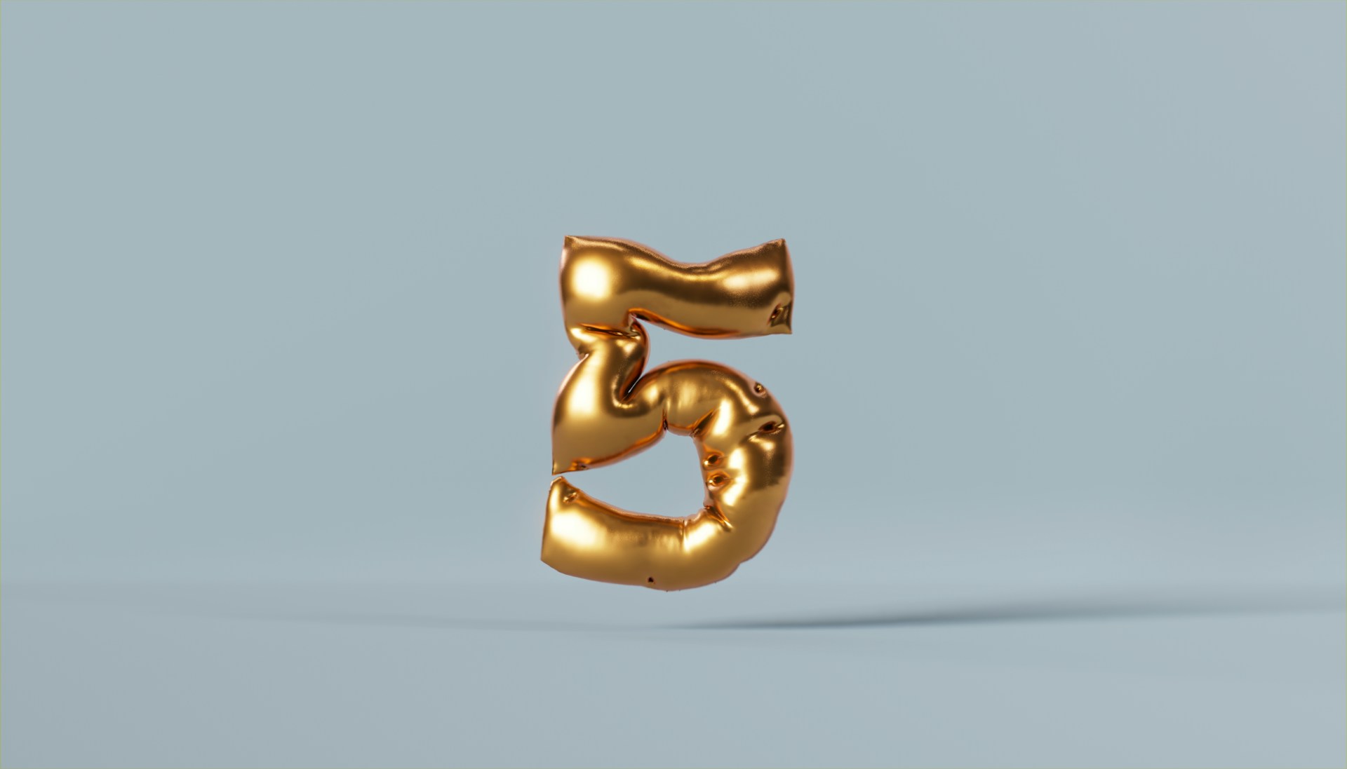 A gold-colored helium balloon in the shape of number 5