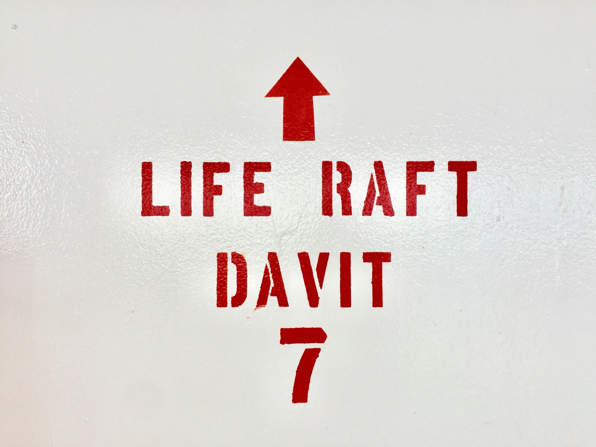 The words 'life raft' and 'davit' painted on a vessel
