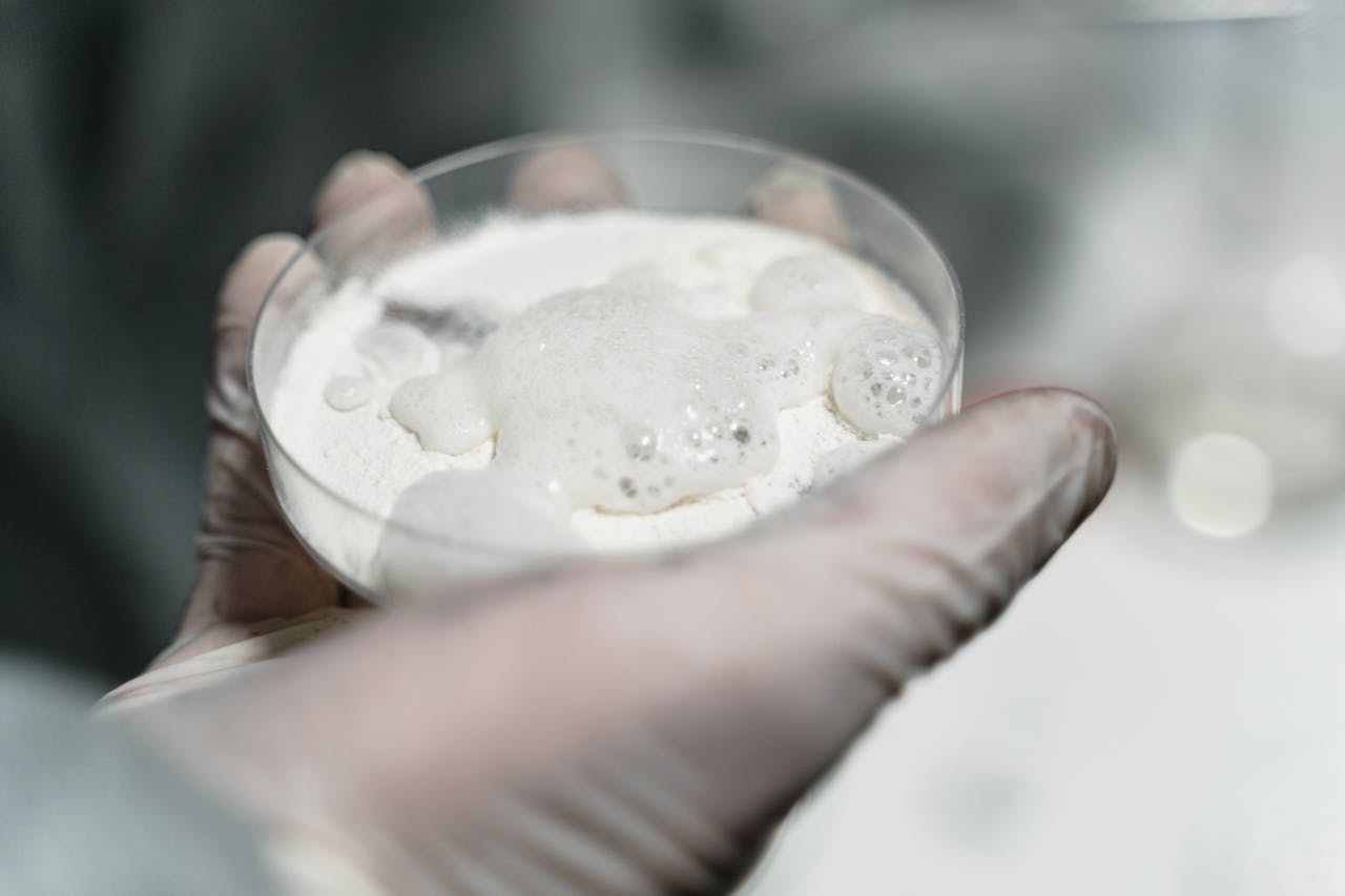 A hand holding cocaine in a petri dish